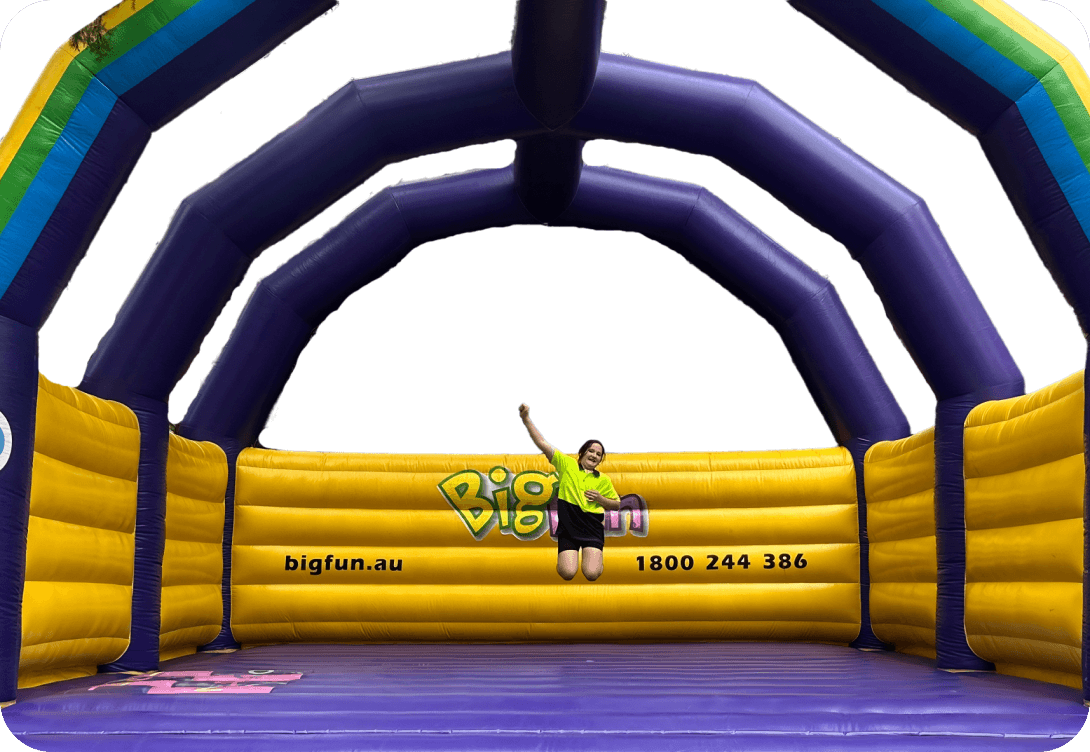 Person jumping on inflatable bouncy castle.
