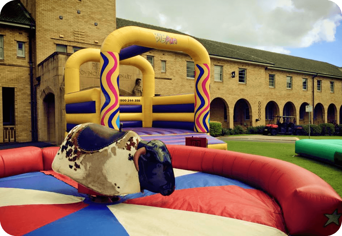 Mechanical bull and inflatable structure outdoors.